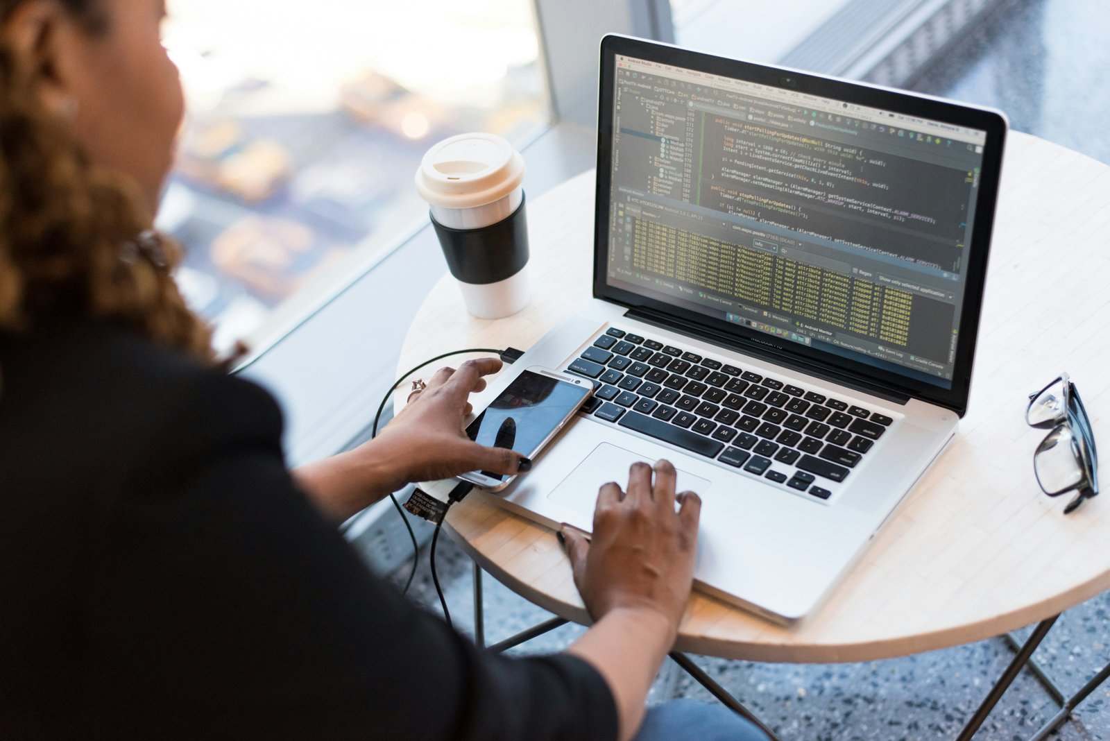 A developer working across a laptop and mobile device