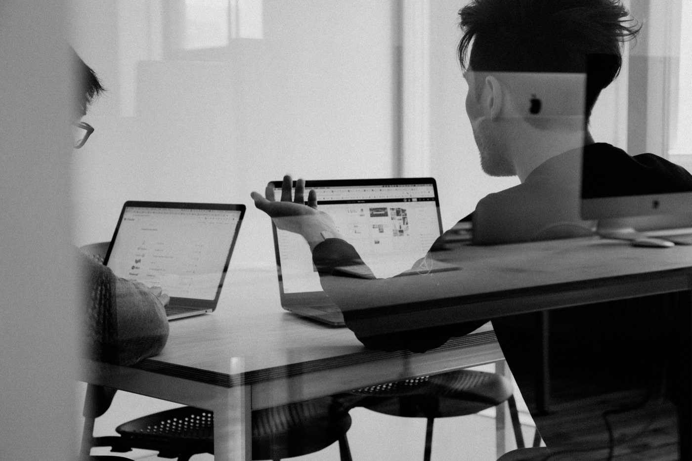 Two colleagues working side by side over laptops